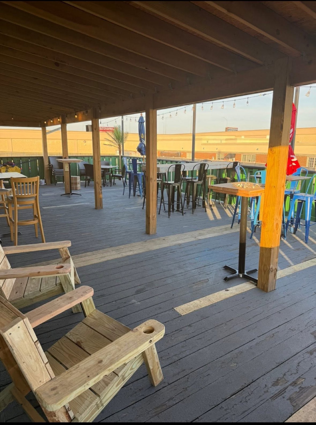 The covered outdoor deck with tables and chairs at Mayfair Bar and Grill